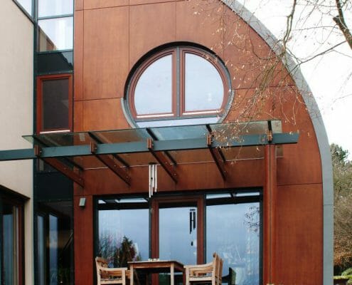 Die ungewöhnliche Hausform wird durch die individuell angefertigten Holzfenster unterstrichen.