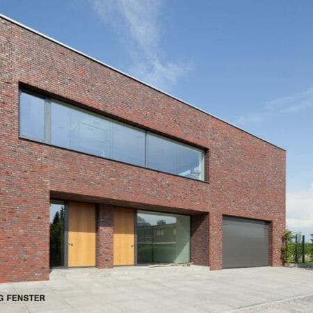 Die von BRÖCKING FENSTER gefertigten Haustüren aus eichenholz sorgen für einen angenehmen Kontrast zu den Aluminum-Fensterelementen.