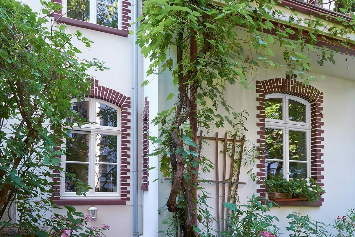 Klassische Holzfenster mit profilierten Sprossen als Stichbogen